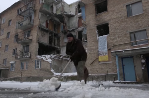Ucraniana retira excesso de neve de sua rua: apagões dificultam aquecimento contra frio intenso (Foto: capt vídeo)
